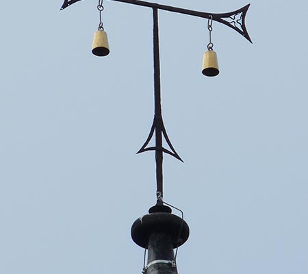 Antoniterkreuz mit Glöckchen auf Kirchturm